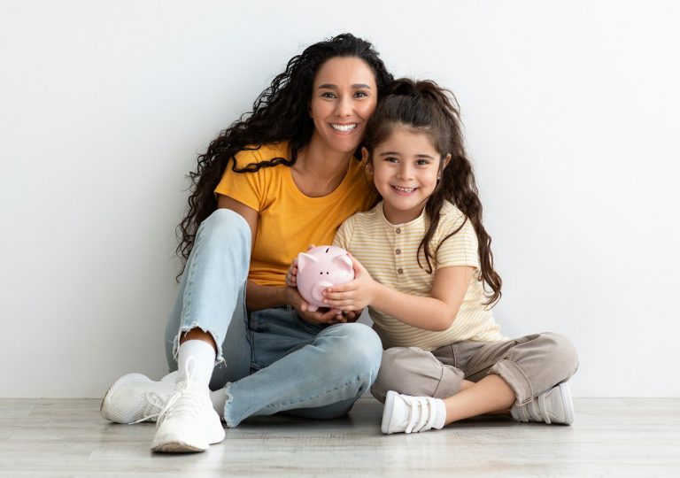 Family Savings. Happy Arab Mother And Cute Little Girl Posing With Piggibank