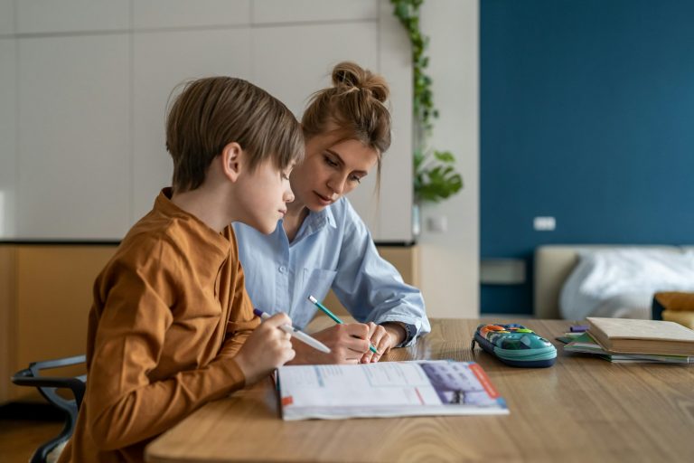 Schoolboy having lesson with private teacher at home